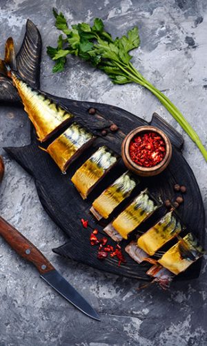 Smoked fish on kitchen board.Smoked mackerel.Smoked fish with spices